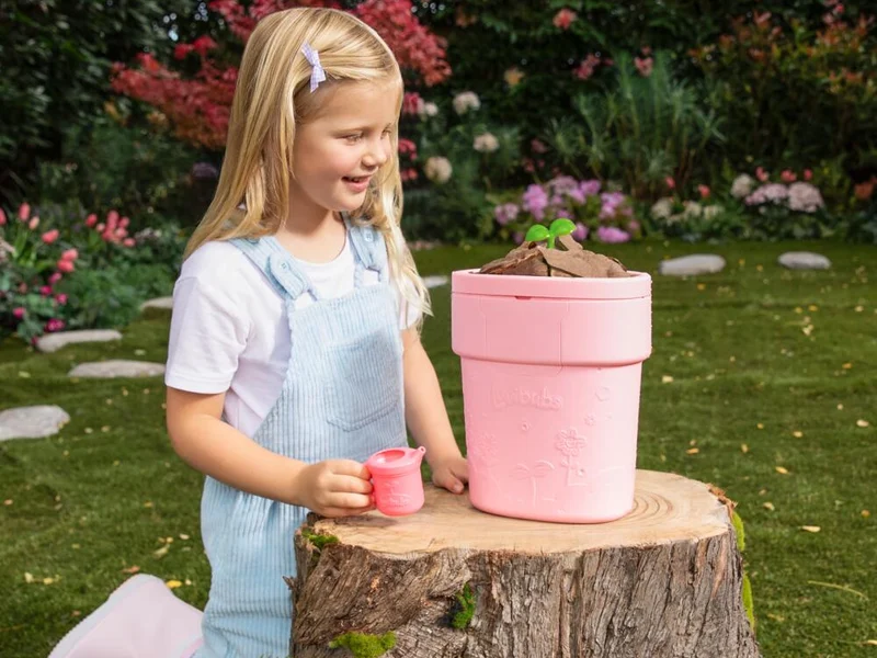 Little girl watching her Luvibubs Doll Single Pack Brave Bella pop out of a pink pot.
