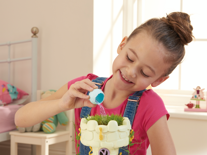 Girl pouring water onto her My Fairy Garden Playset.