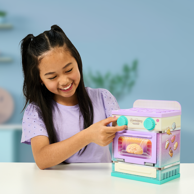Young girl turning the oven temperature on her Lil' Bakez playset. 
