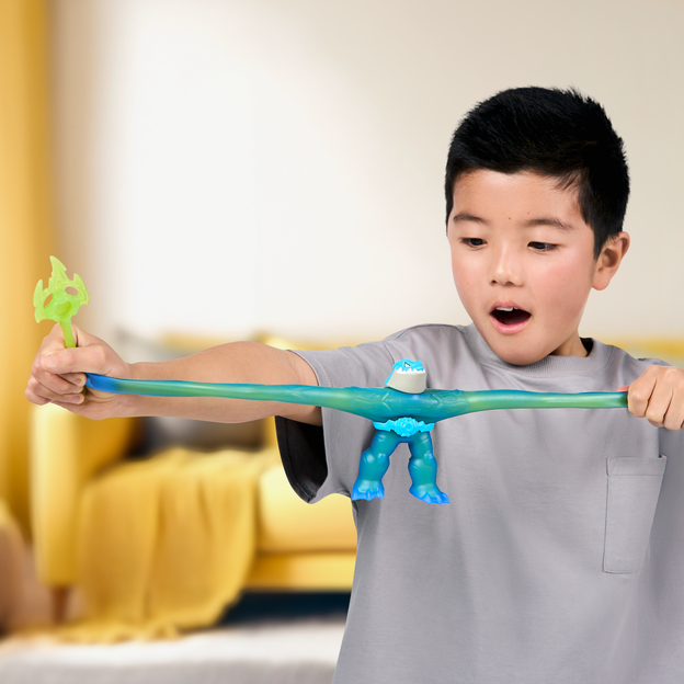 Young boy stretching a blue Heroes of Goo Jit Zu toy from its arms. 