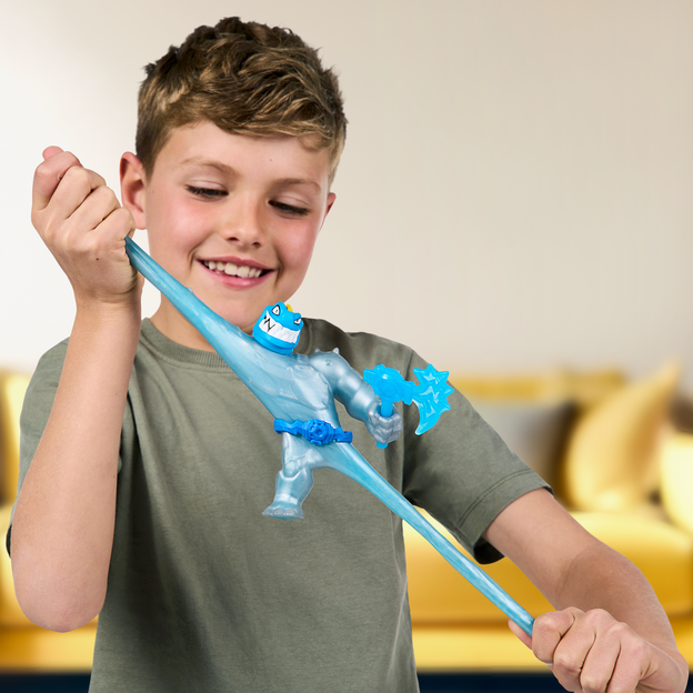 You boy stretching a blue Heroes of Goo Jit Zu toy by its arms. 