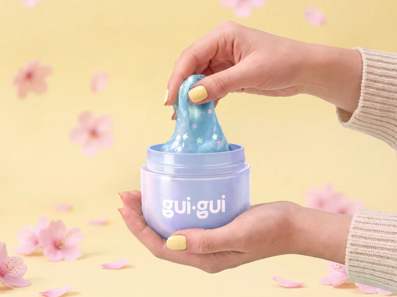 Hands stretching blue gui.gui slime from a slime container