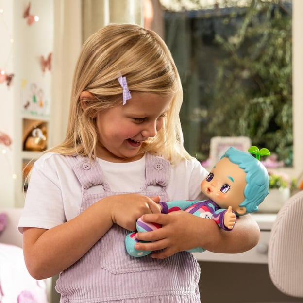 Young girl craddling a Luvibubs Brave Bella toy in her arms.