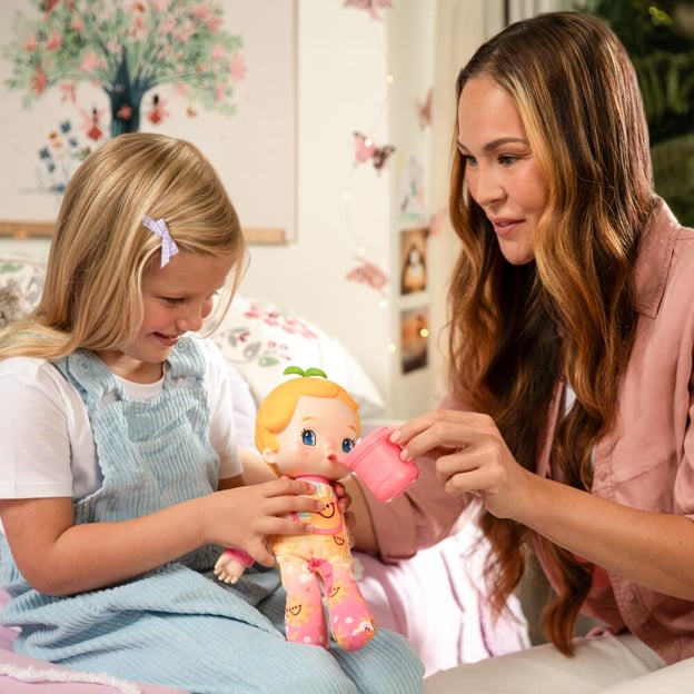 Mother and daughter feeding a Luvibubs Doll Single Pack Cheerful Charlie toy. 