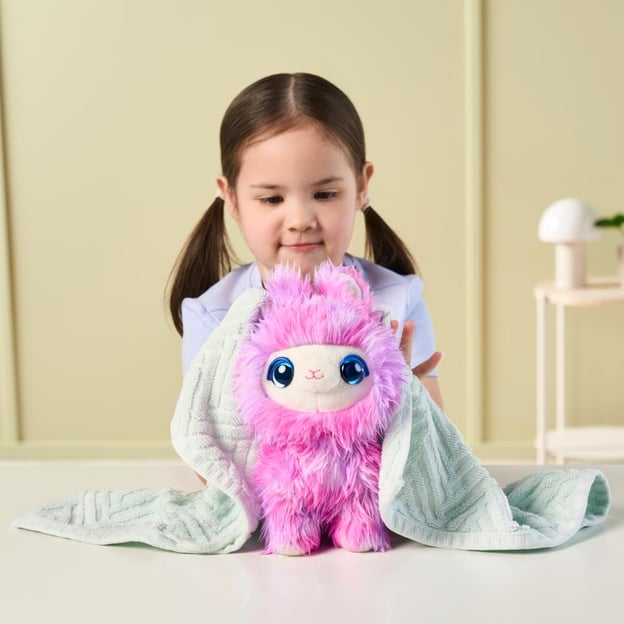 Young girl drying a pink ScruffaLuvs Tiedye toy with a towel.