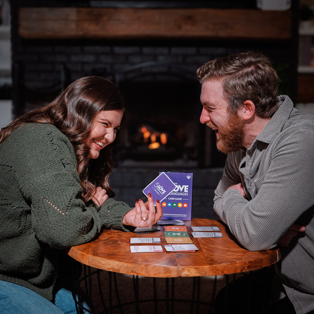 A couple giggling over the 5 love languages card game. 