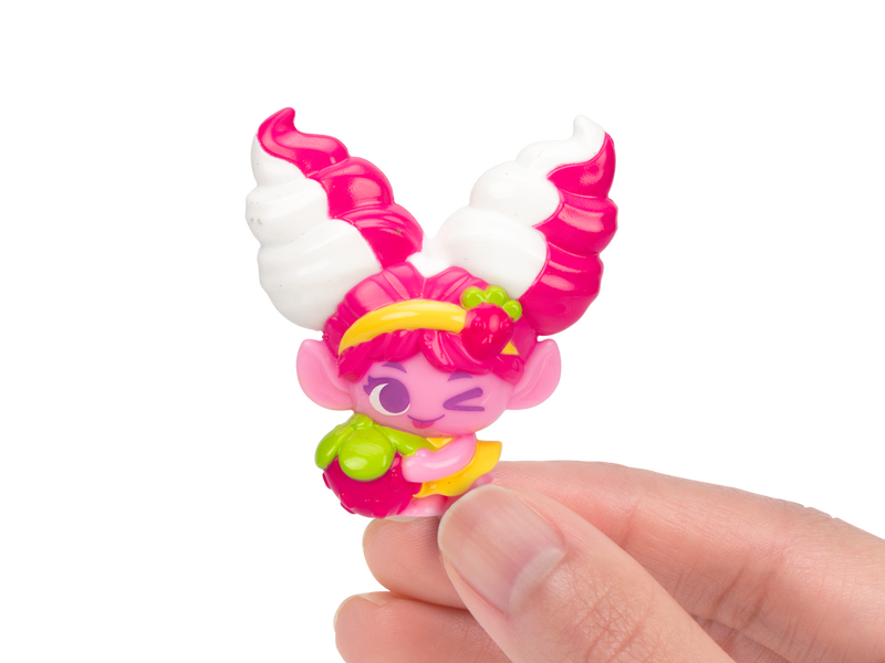 Hand holding a small pink Trolls figurine between their fingers. 
