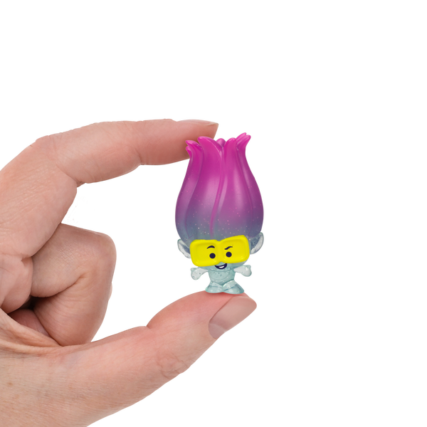 A small Trolls figurine held between two fingers. 