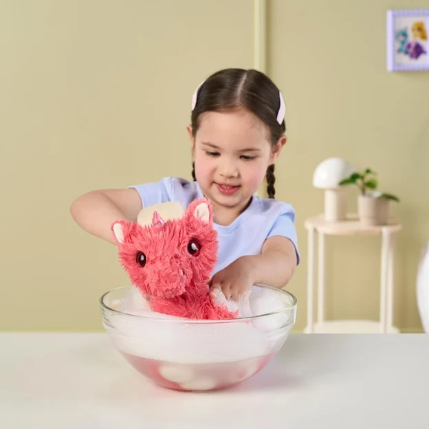 Young girl washing a ScruffaLuvs Coral Pet.