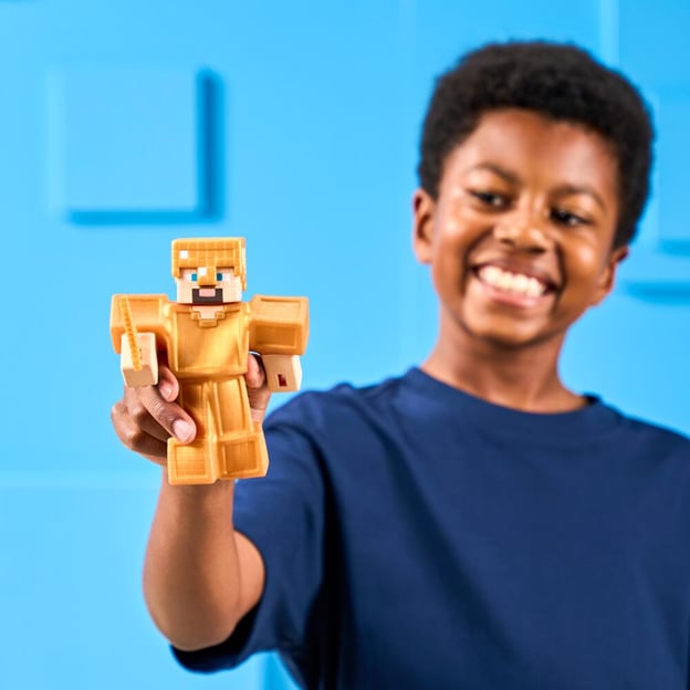 Young boy holding a Goo Jitzu Minecraft S4 Hero Pack Gold Armor Steve toy.