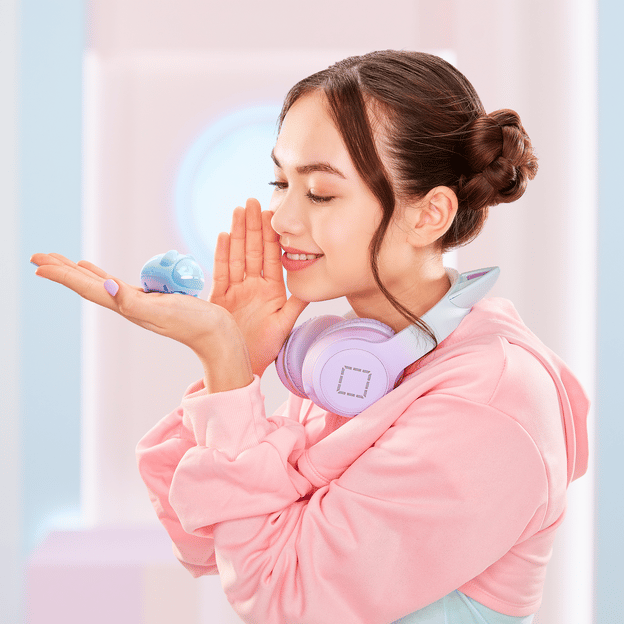 Young girl holding her hand up to her face as if she's whispering to a blue micropet toy she is holding up in her other hand.