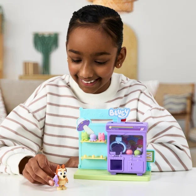Young girl playing with her Bluey S15 Mini Playset Claw Machine toy.