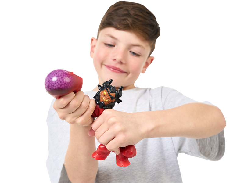 Boy pressing the gooey arm of a red Heroes of Goo Jit Zu toy. 