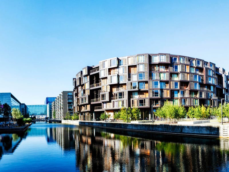 escenario de un edificio y su reflejo junto a un cuerpo de agua