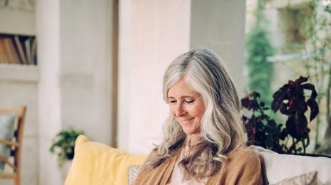 Mujer madura sentada observando su tablet