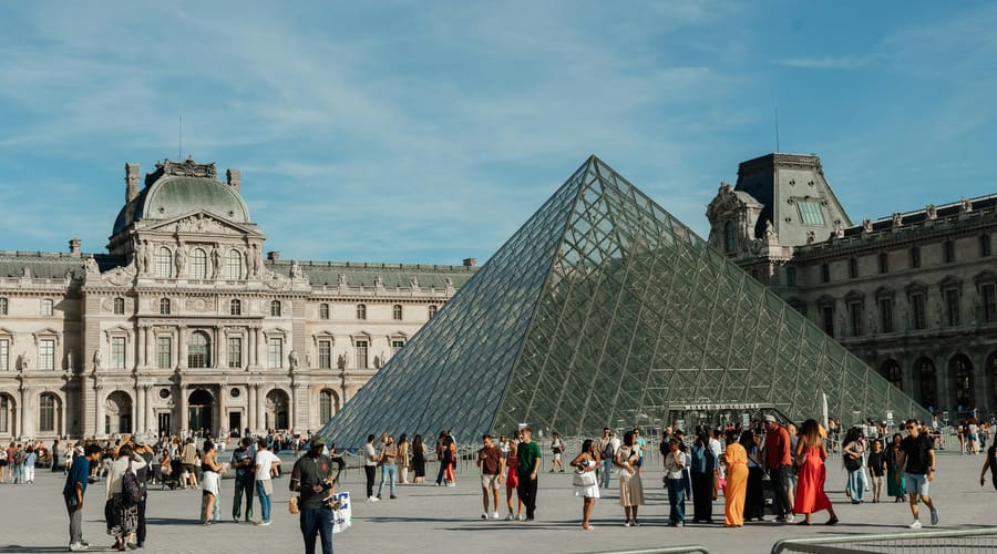 Personas caminando en París mientras piensan en estudiar con un curso de francés.