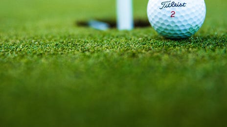 Pelota de golf junto al hoyo