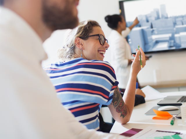 Mujer exponiendo frente a un grupo de adultos alegres