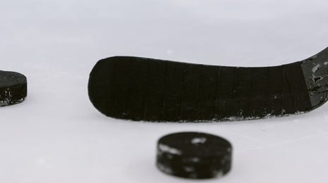 Puck y palo de hockey sobre el hielo de la pista