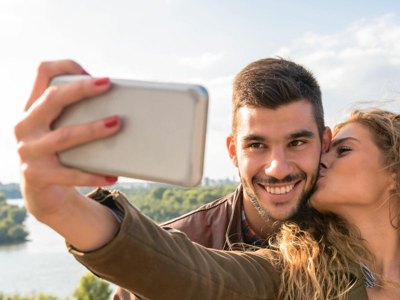 Pareja sacando fotos y diciendo te amo en inglés
