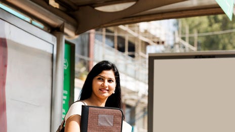 Mujer feliz cargando sus libros saliendo de una clase de idiomas