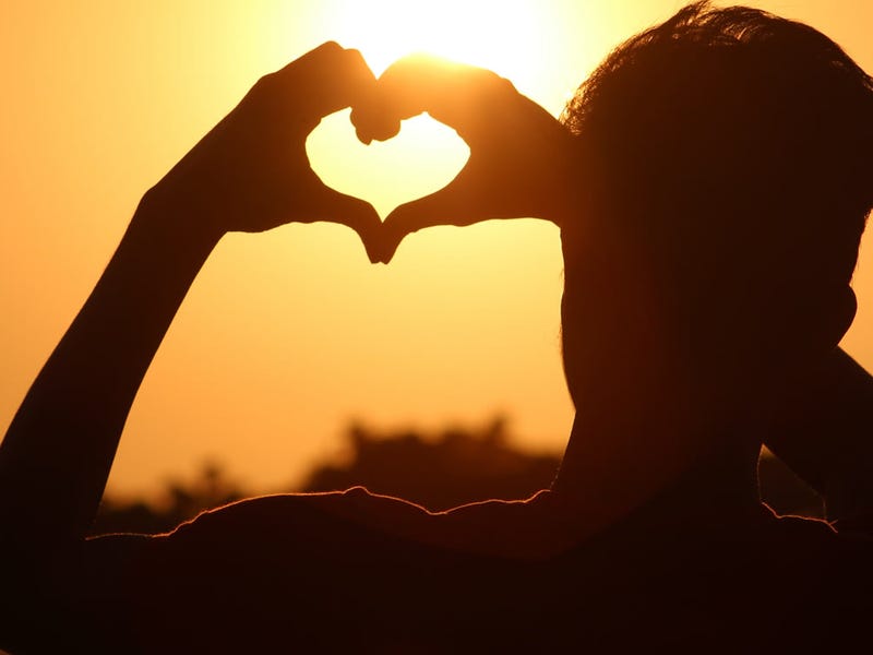 Un hombre haciendo con las manos la forma de un corazón