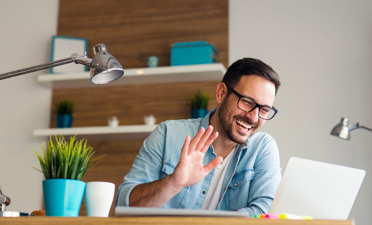 Hombre saludando en una videollamada