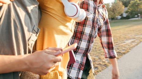 Jóvenes felices abrazados caminando por la calle