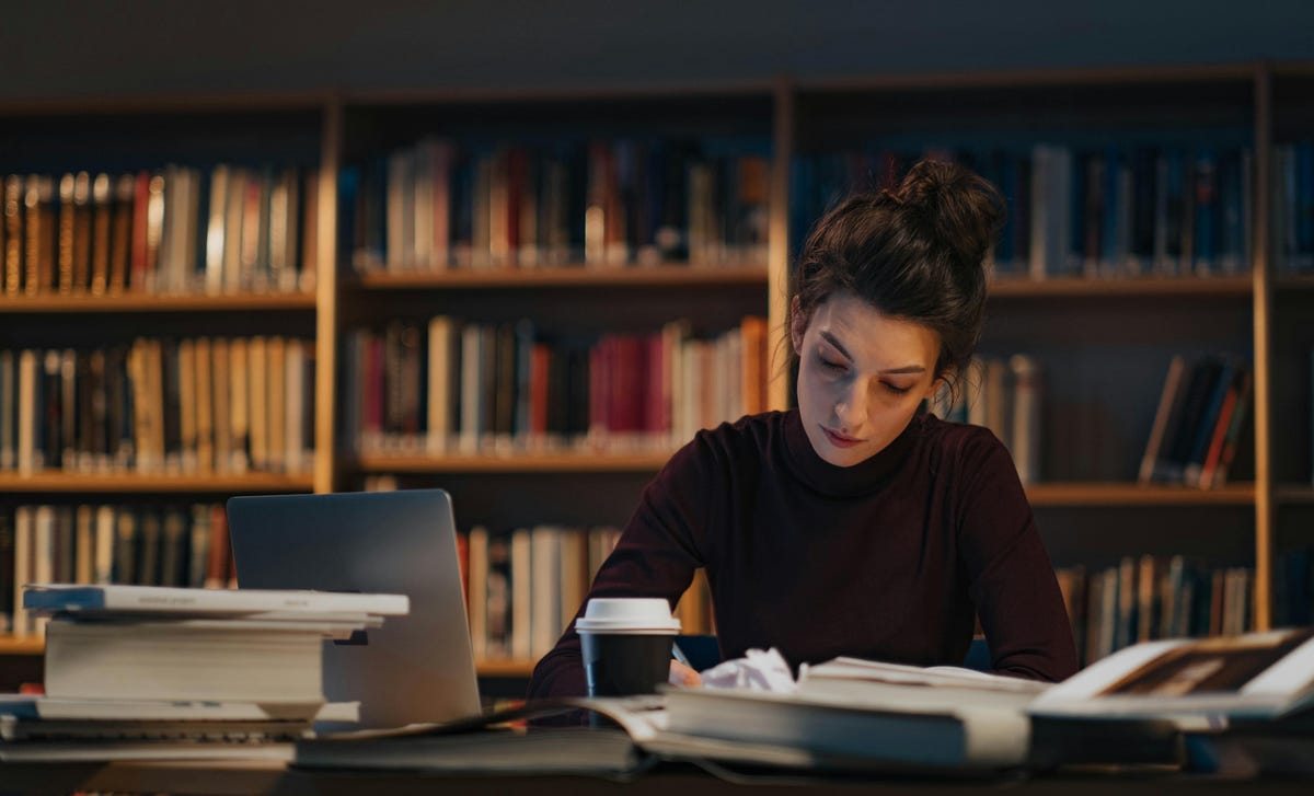 Mujer estudiando con los materiales de su curso de portugués de Berlitz.