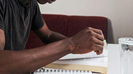 Chico leyendo un libro para adaptarse a sus necesidades personales de aprendizaje.