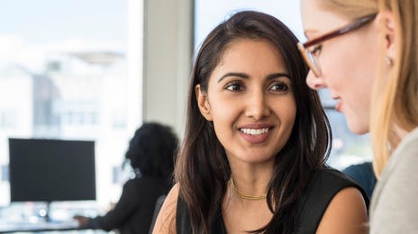 Dos mujeres en una oficina platicando en portugués