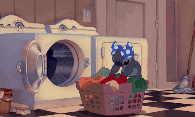 Stitch bawi się ubraniami w pralni.