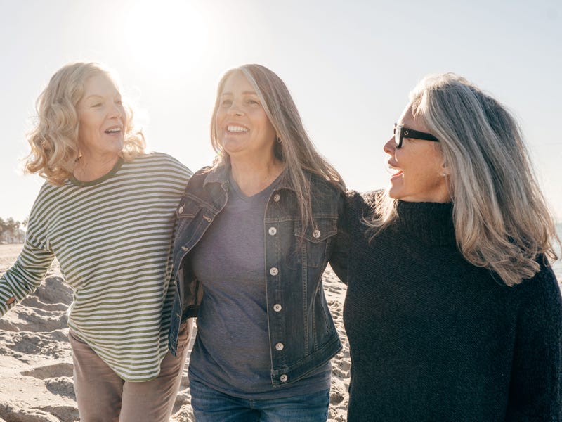 Mujeres paseando por la playa y platicando