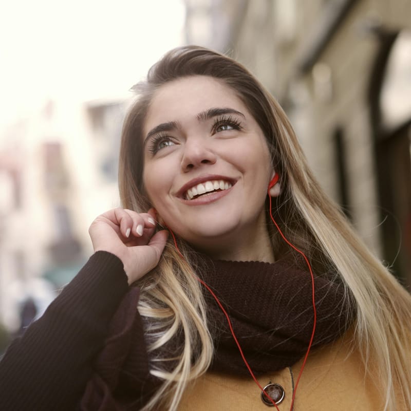 Mujer soltera con sus audífonos aprendiendo sobre los estados civiles en inglés.