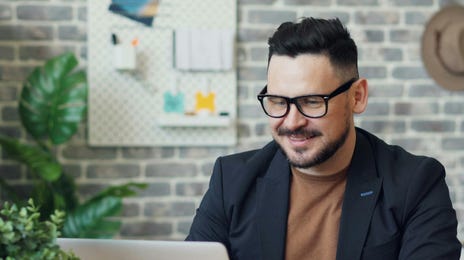 Hombre trabajando con su computadora en el teletrabajo.