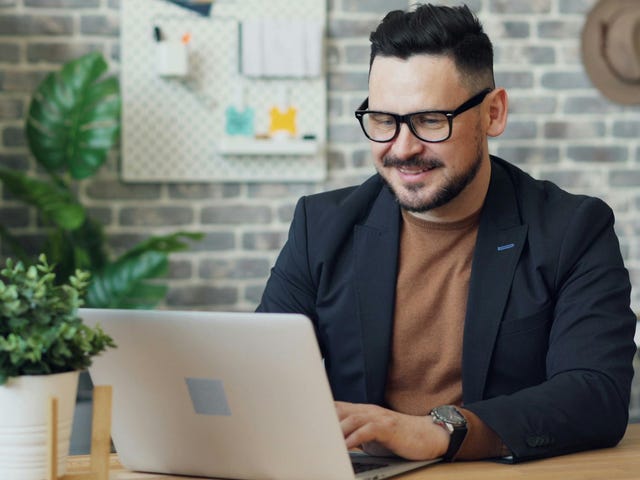 Hombre trabajando con su computadora en el teletrabajo.