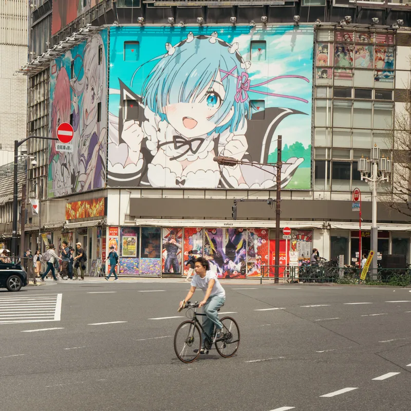 Calle en Japón con un dibujo de anime en un edificio para representar la cultura pop.