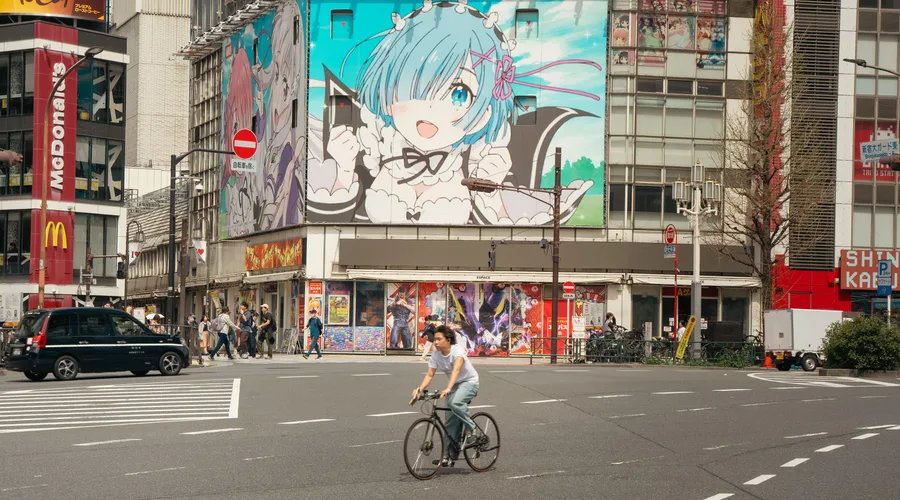 Calle en Japón con un dibujo de anime en un edificio para representar la cultura pop.