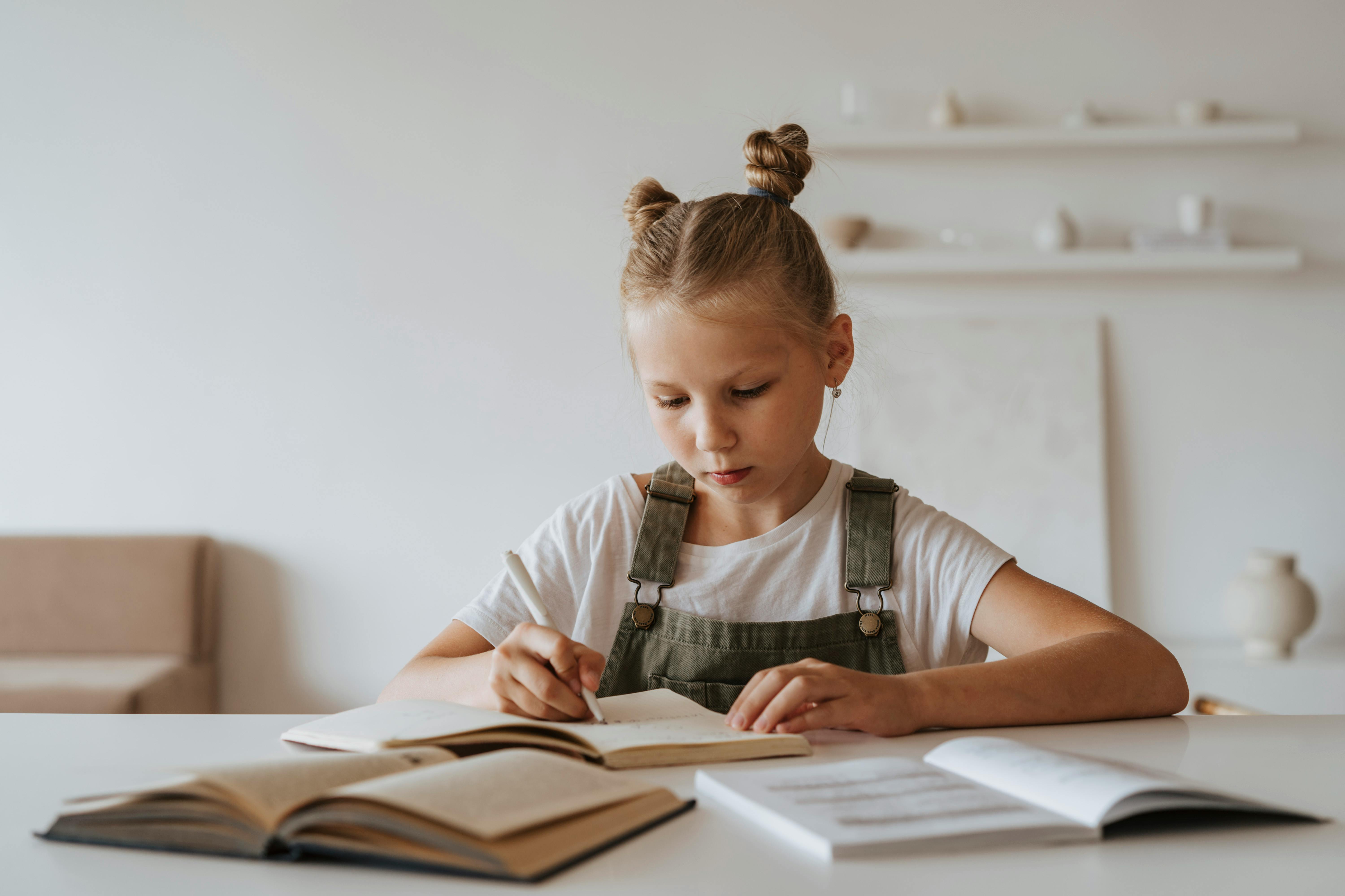 Niña rubio estudiando alemán con su libro de historia.