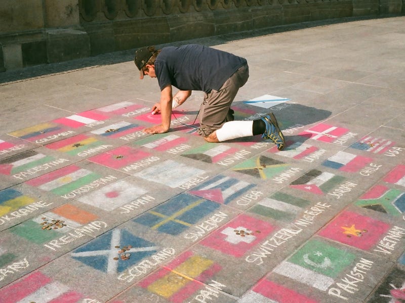 Un hombre pintando banderas del mundo