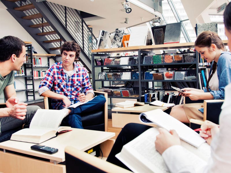 cuatro jóvenes en una biblioteca.