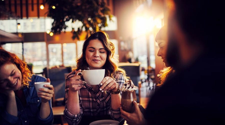 un grupo de adultos jóvenes sosteniendo diversos tipos de café en francés