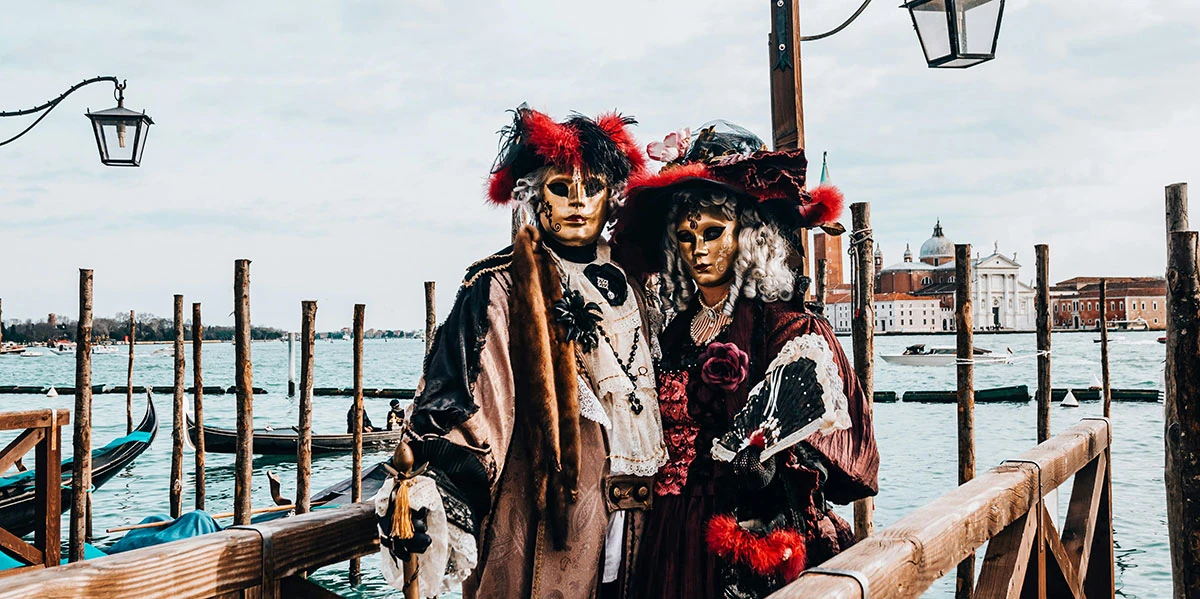 Pareja hablando en el idioma inglés en el Carnaval de Venecia