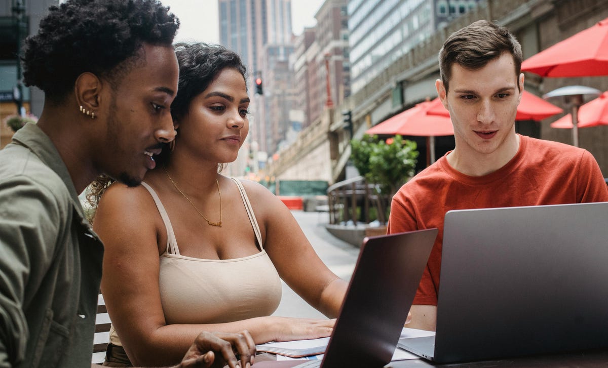 Tres amigos buscando las mejores modalidades de cursos de idiomas.