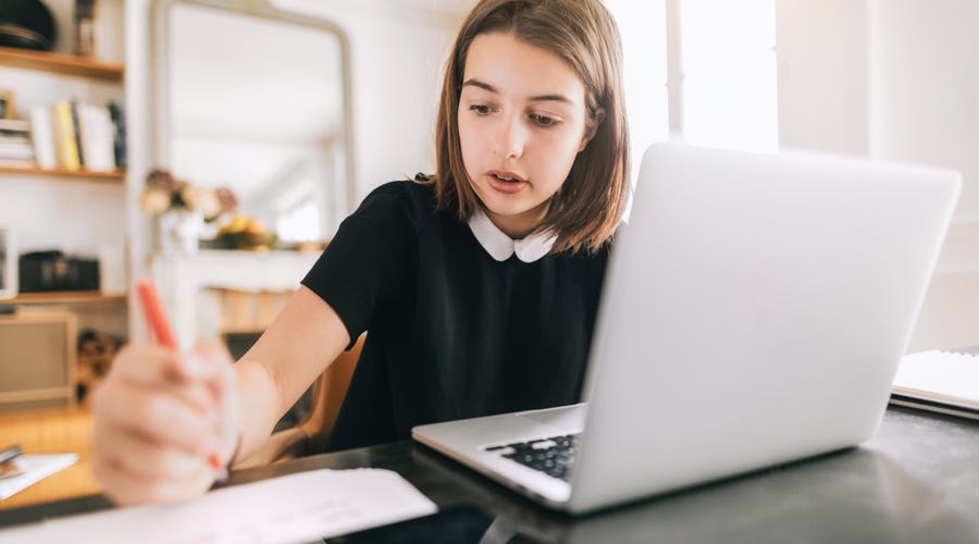 Una niña estudiando en su computadora