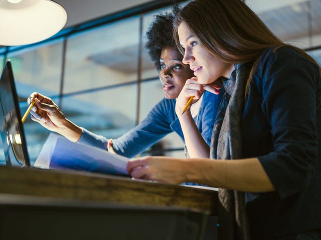 Dos mujeres reunidas observando algo en una computadora