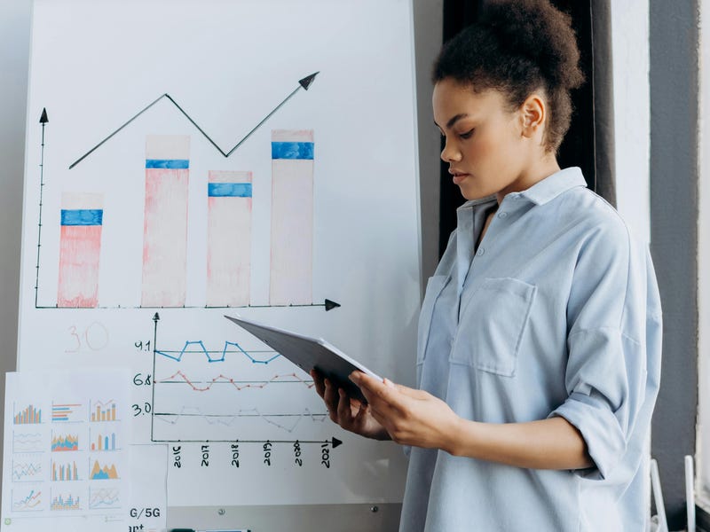 Mujer estudiando el reporte de tu empresa.