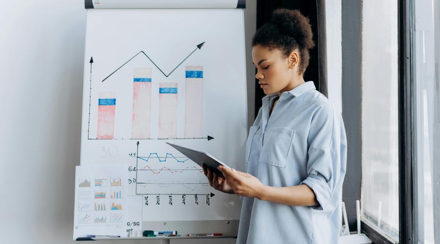 Mujer estudiando el reporte de tu empresa.