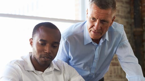 Profesor instruyendo a un alumno en un salón luminoso