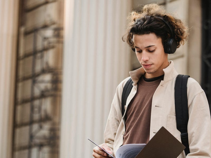 Chico con papeles en las manos, estudiando en un curso de inglés intensivo.